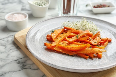 Plate with tasty sweet potato fries on marble table, closeup