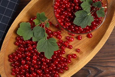 Ripe red currants and leaves on wooden table, top view