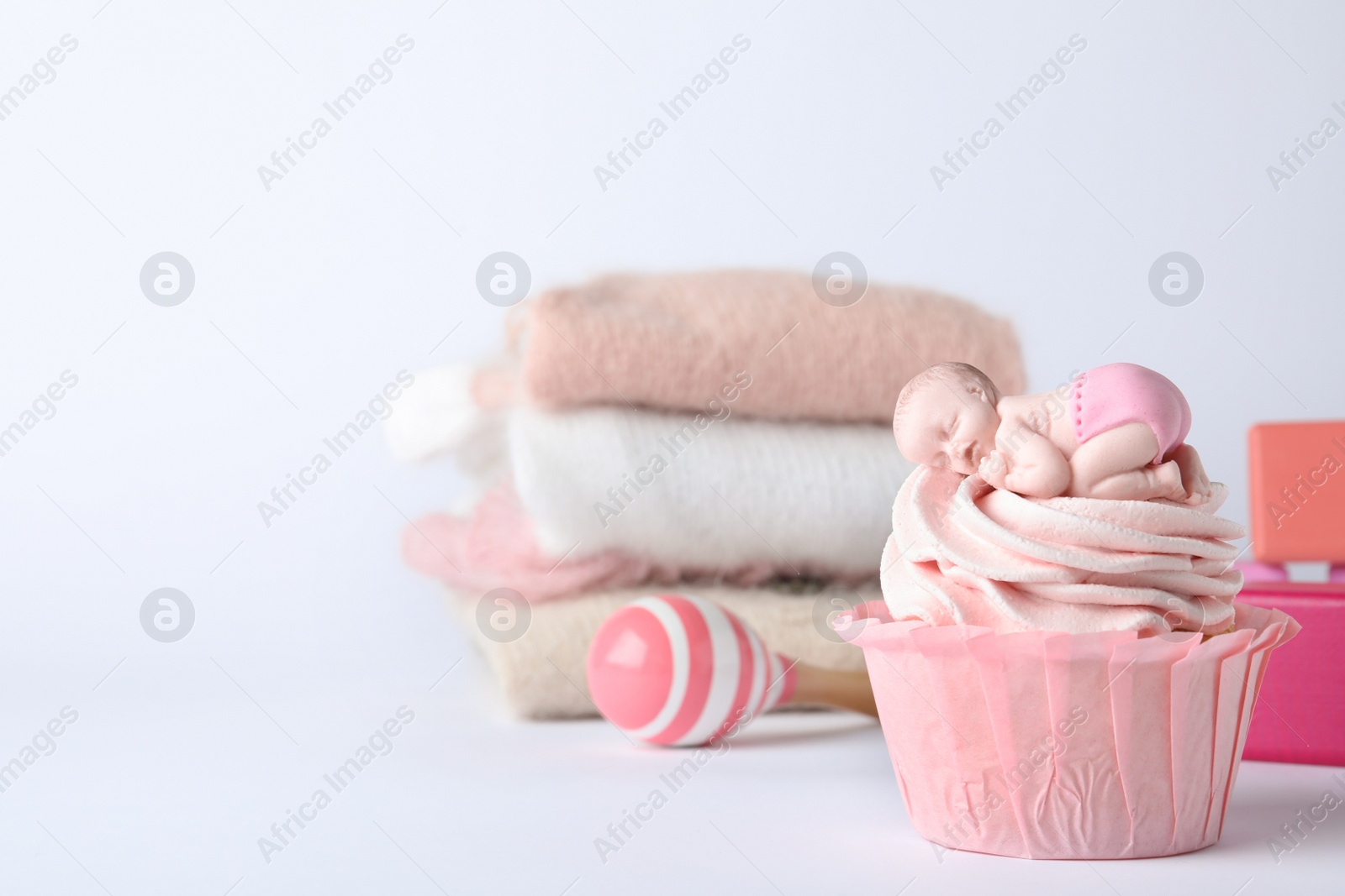 Photo of Beautifully decorated baby shower cupcake with pink cream and girl topper on light background. Space for text