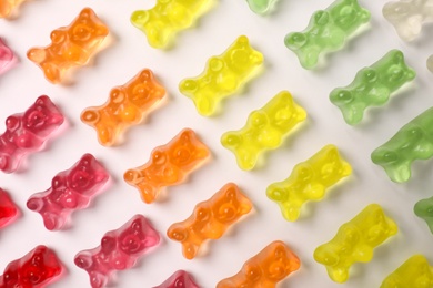 Many delicious little jelly bears on white background, top view