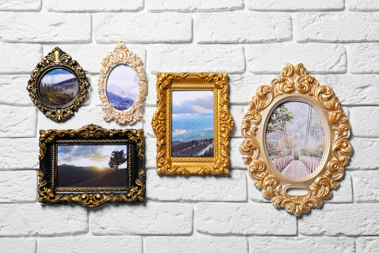 Photo of Vintage frames with photos of beautiful landscapes hanging on white brick wall