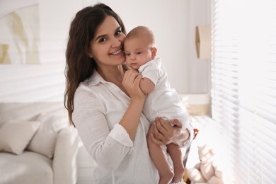 Photo of Happy young mother with her cute baby at home