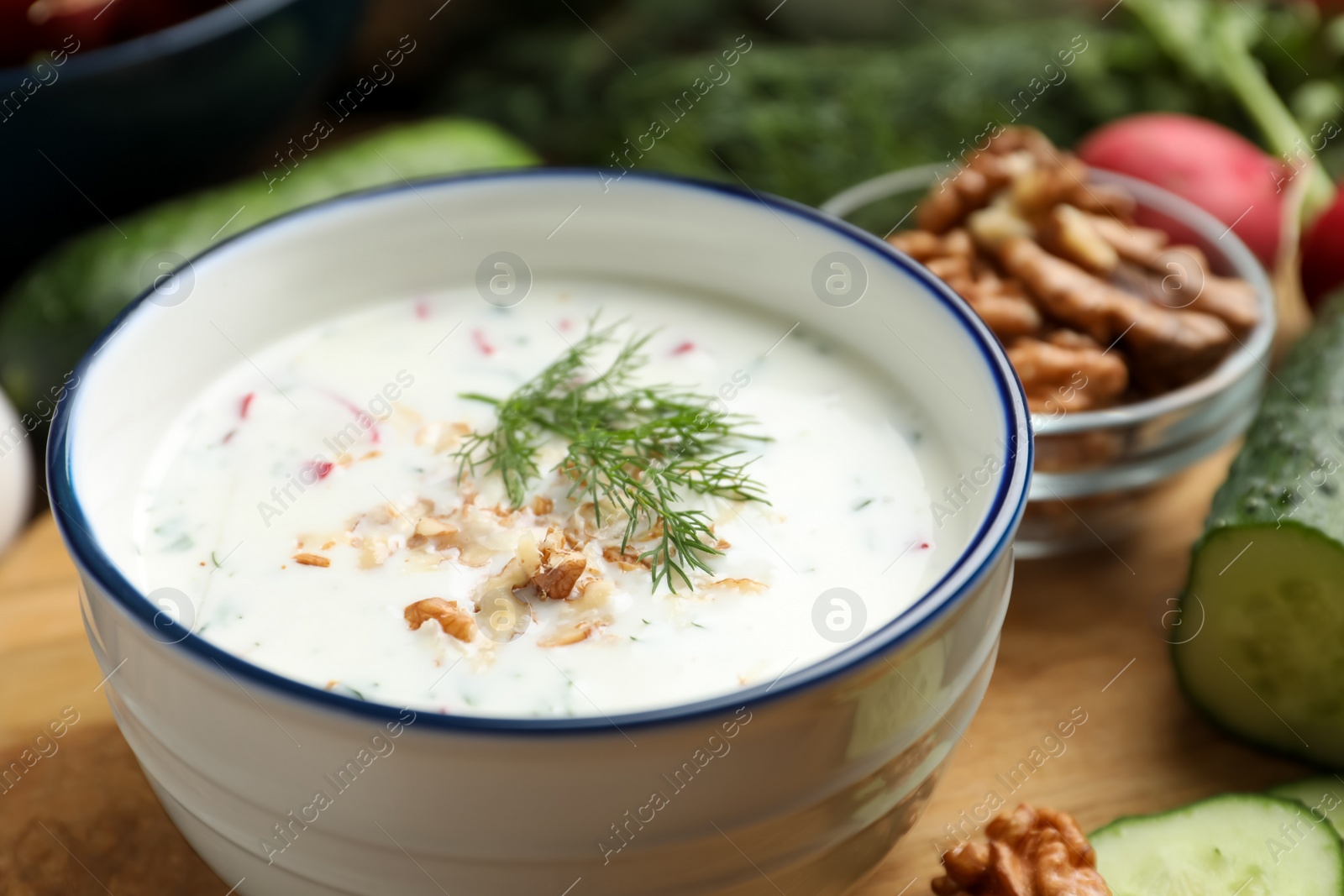 Photo of Delicious cold summer soup on wooden board, closeup