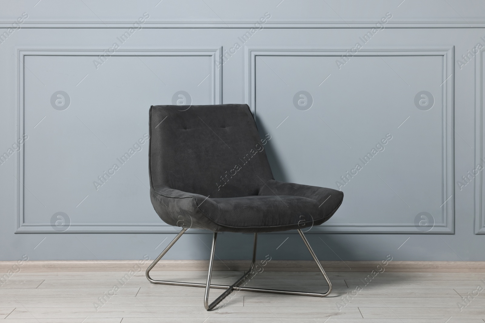 Photo of Comfortable armchair near grey wall in room