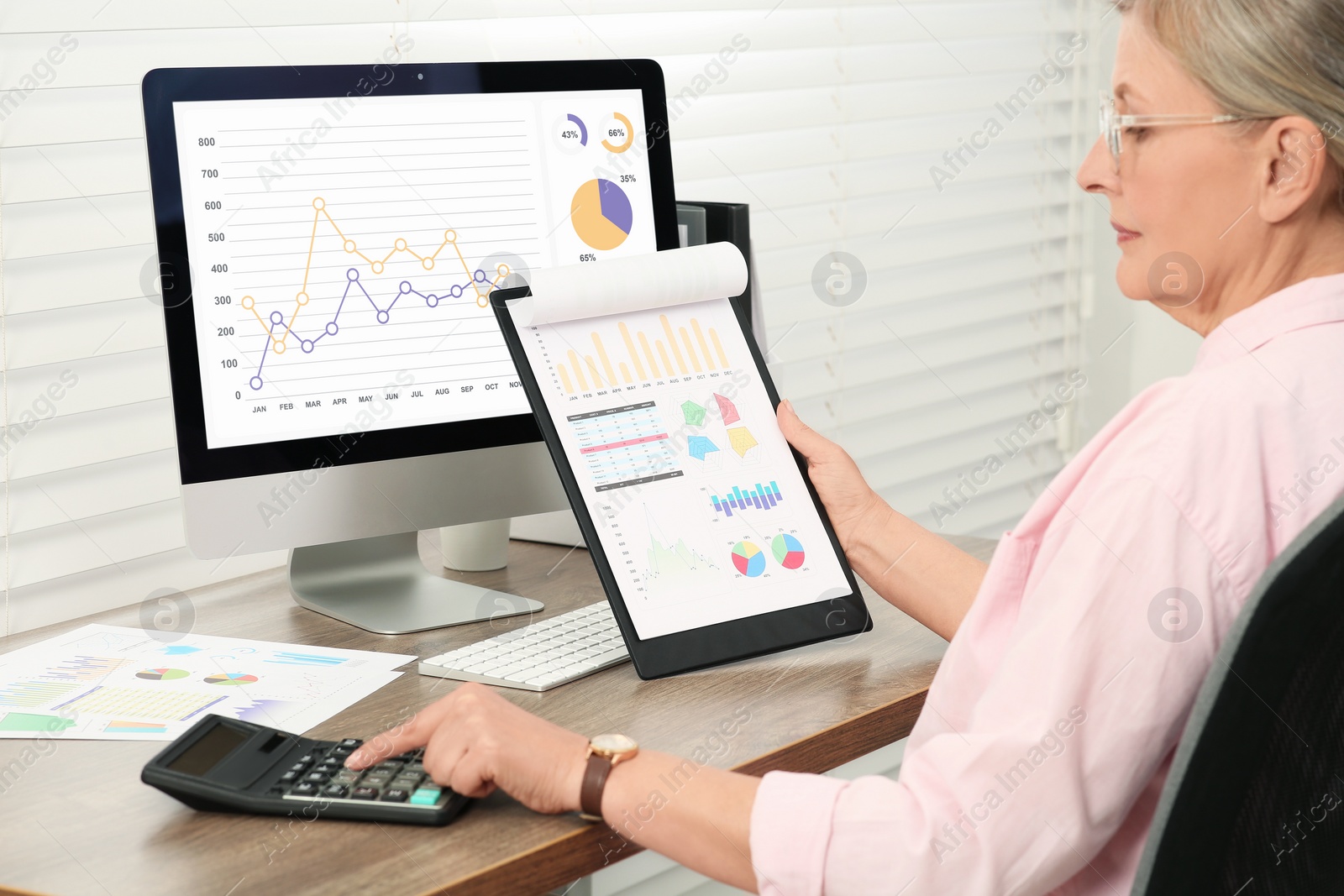 Photo of Senior accountant working at wooden desk in office