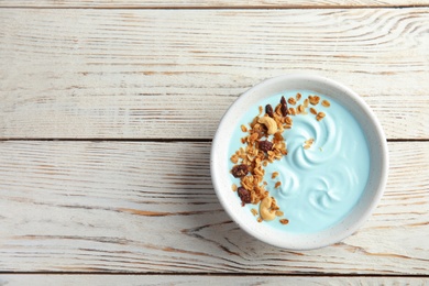 Photo of Bowl of spirulina smoothie on wooden background, top view with space for text