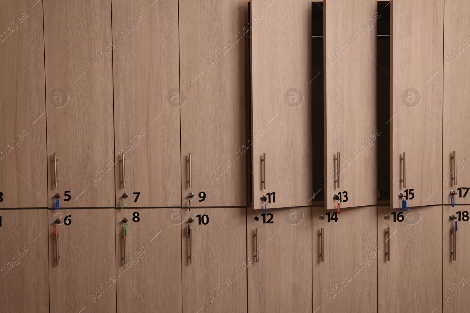 Photo of Many wooden lockers with keys and numbers on doors