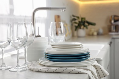 Photo of Different clean dishware and glasses on countertop in kitchen