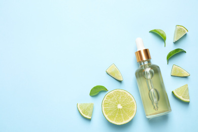 Photo of Flat lay composition with lime essential oil on light blue background. Space for text