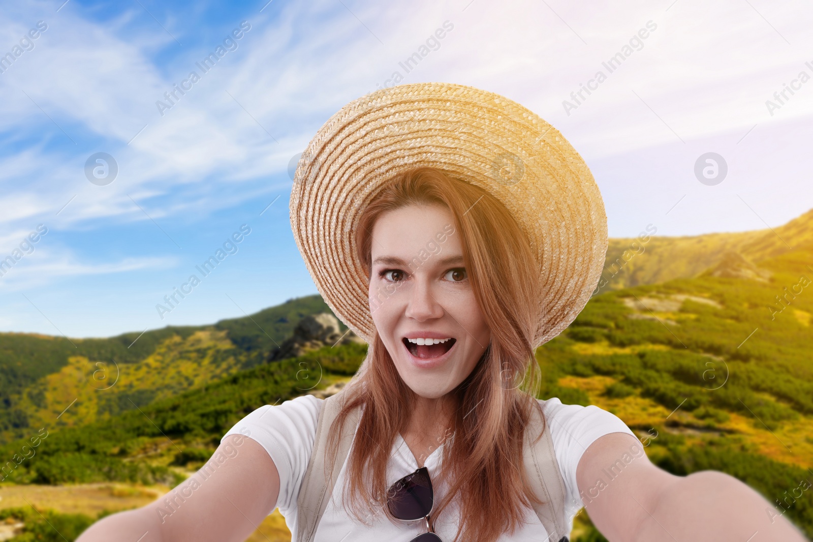 Image of Beautiful woman in straw hat taking selfie in mountains