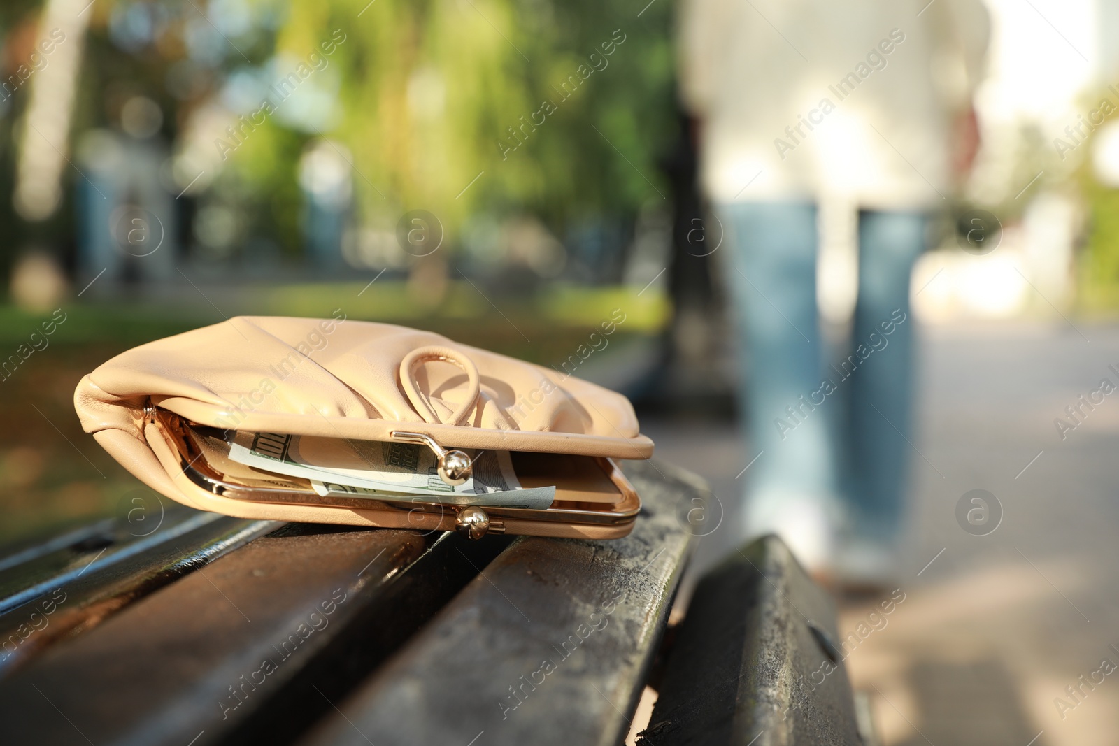 Photo of Woman lost her purse on wooden surface outdoors, selective focus