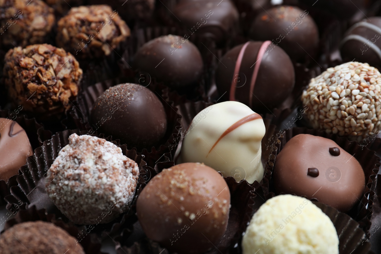 Photo of Different tasty chocolate candies as background, closeup