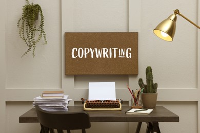 Image of Cork board with word Copywriting, typewriter, plants and stationery in stylish room