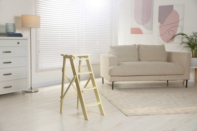 Photo of Folding ladder on wooden floor at home