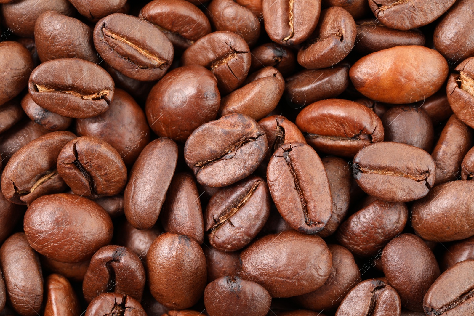 Photo of Aromatic roasted coffee beans as background, top view