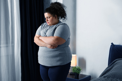 Overweight woman suffering from depression at home