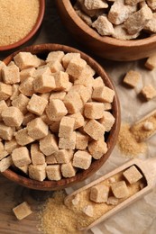 Photo of Different types of sugar on wooden table, above view