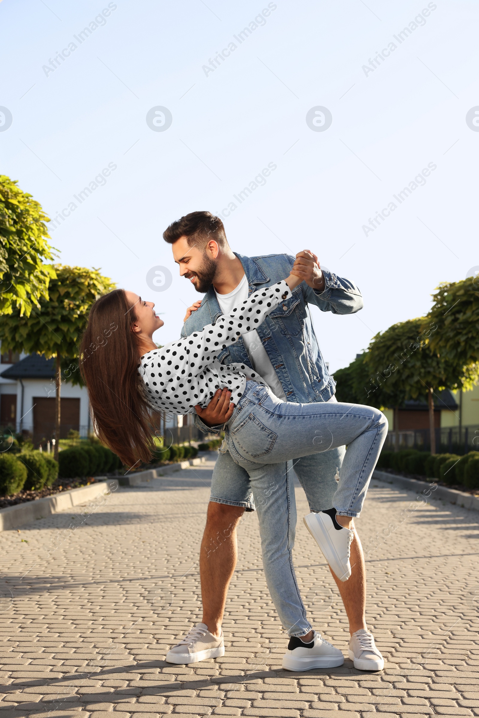 Photo of Happy couple dancing outdoors on sunny day