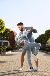 Photo of Happy couple dancing outdoors on sunny day