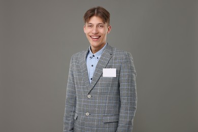 Photo of Happy man with blank badge on grey background