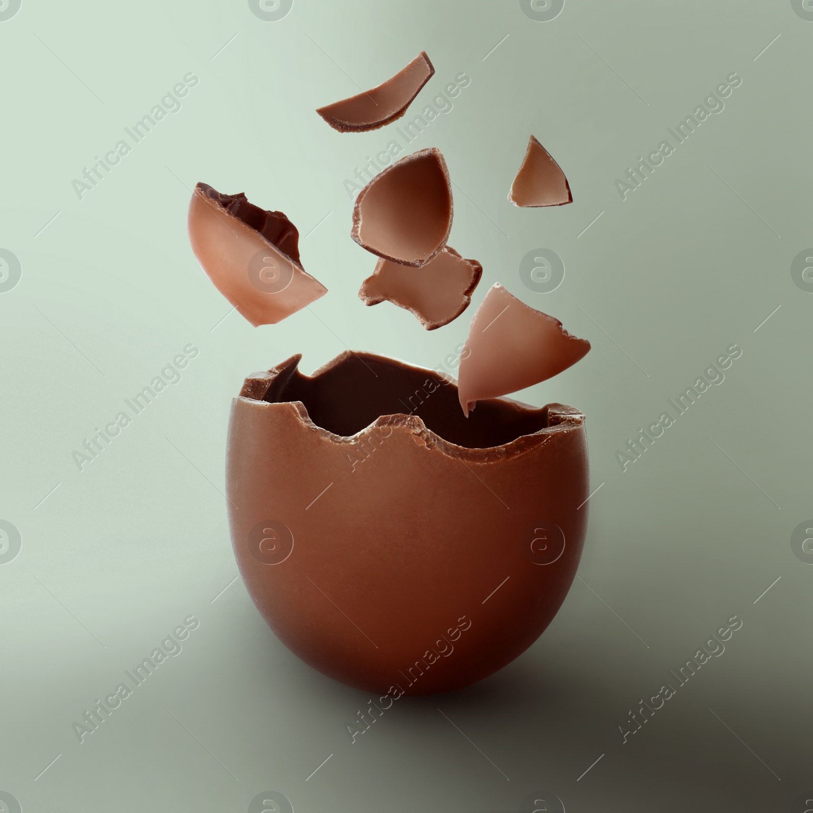 Image of Exploded milk chocolate egg on color background