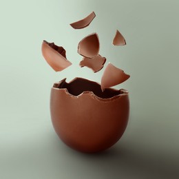 Image of Exploded milk chocolate egg on color background