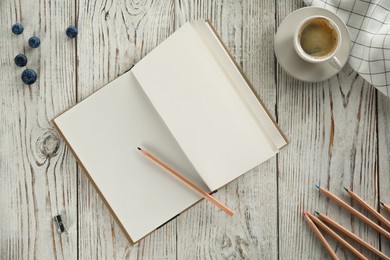 Photo of Flat lay composition with open notebook and cup of coffee on white wooden table