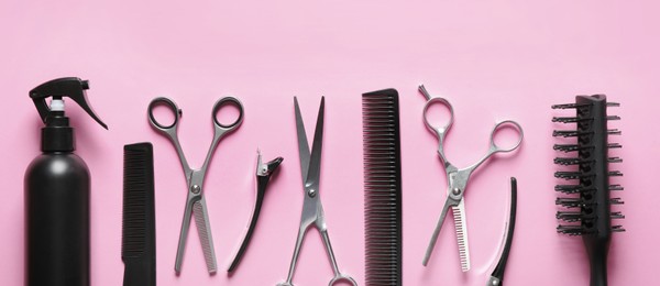 Image of Set with scissors and other hairdresser's accessories on pink background, flat lay. Banner design