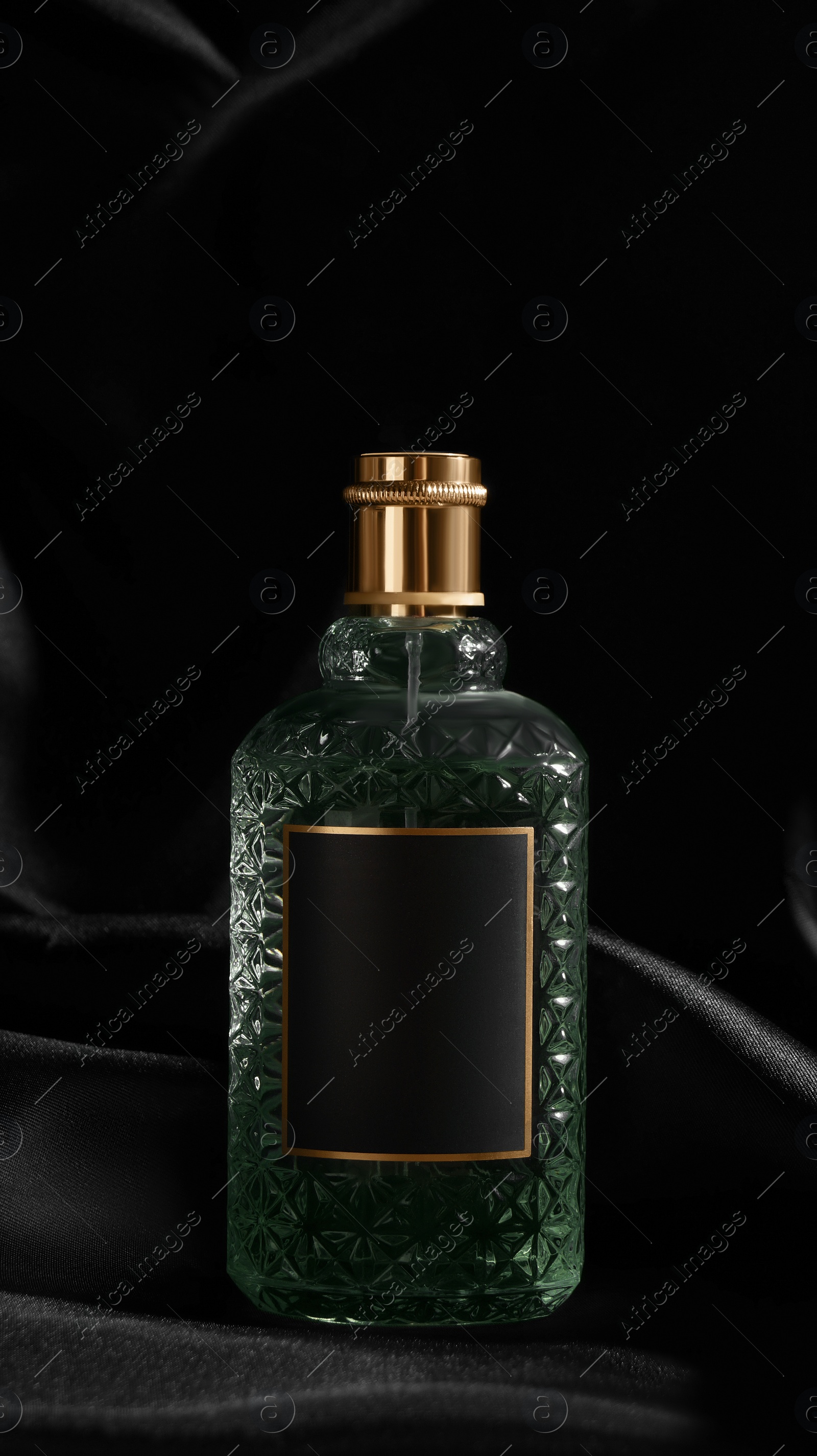 Photo of Luxury bottle of perfume on black silk