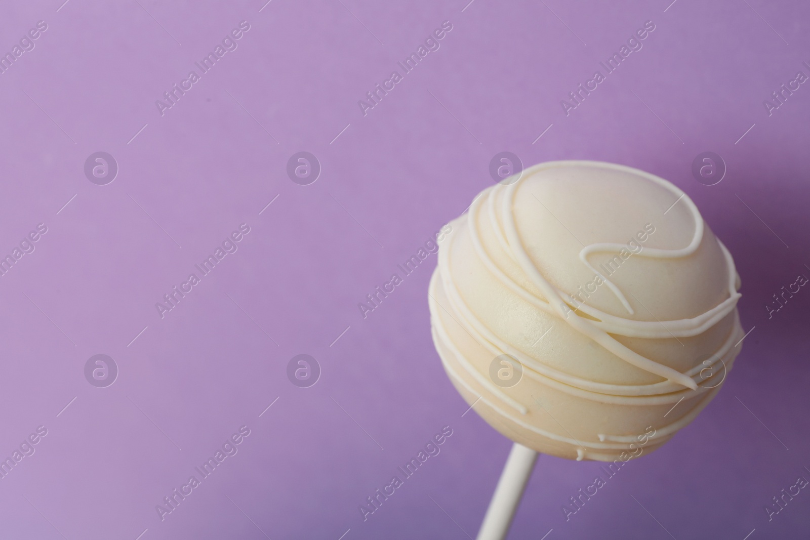 Photo of Sweet cake pop on purple background, space for text