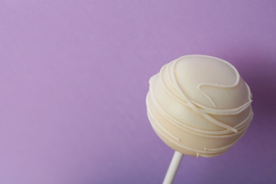 Photo of Sweet cake pop on purple background, space for text