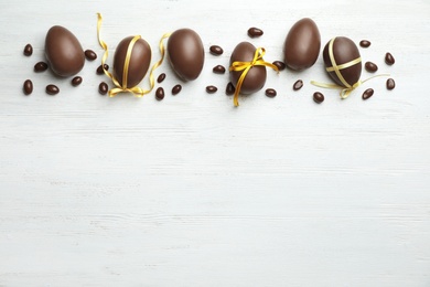 Photo of Flat lay composition with chocolate Easter eggs on wooden background, space for text