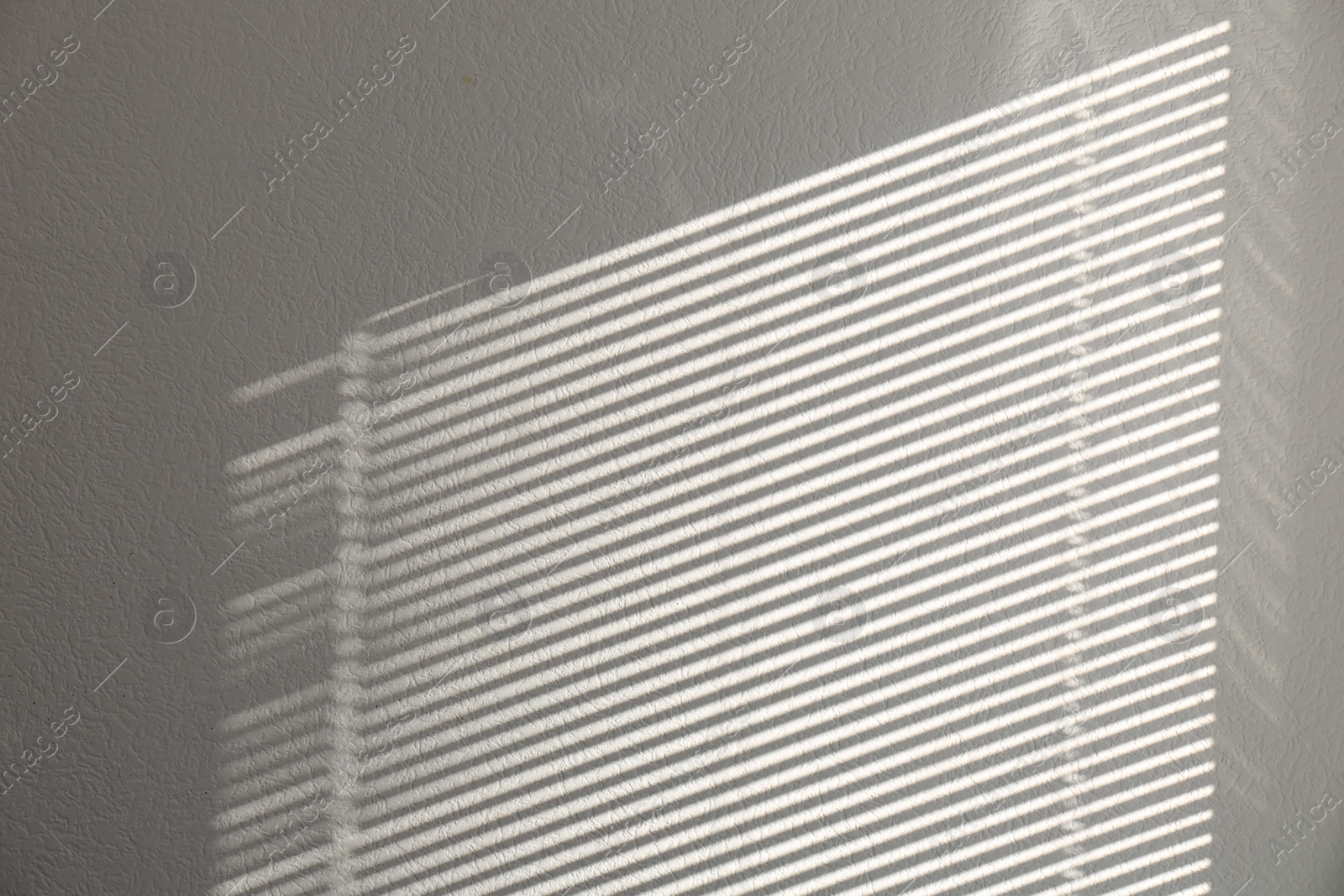 Photo of Light and shadow from window on white wall, space for text