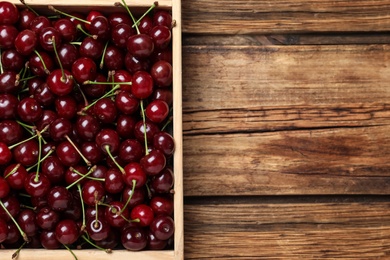 Photo of Sweet juicy cherries on wooden table, top view. Space for text
