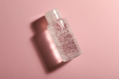 Bottle of cosmetic gel on pink background, top view