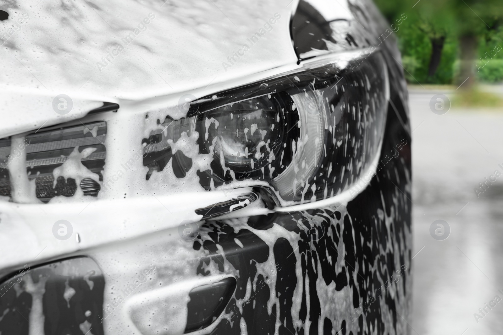 Photo of Auto with cleaning foam at car wash, closeup