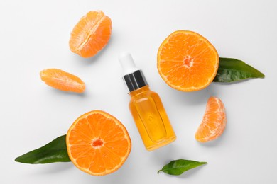 Photo of Aromatic tangerine essential oil in bottle, leaves and citrus fruits on white table, flat lay