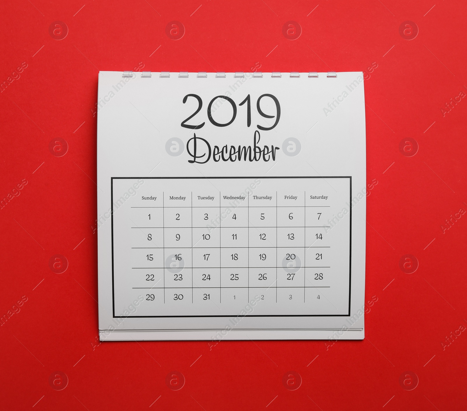 Photo of December 2019 calendar on red background, top view