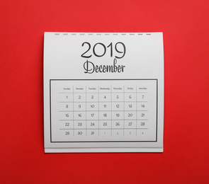 Photo of December 2019 calendar on red background, top view
