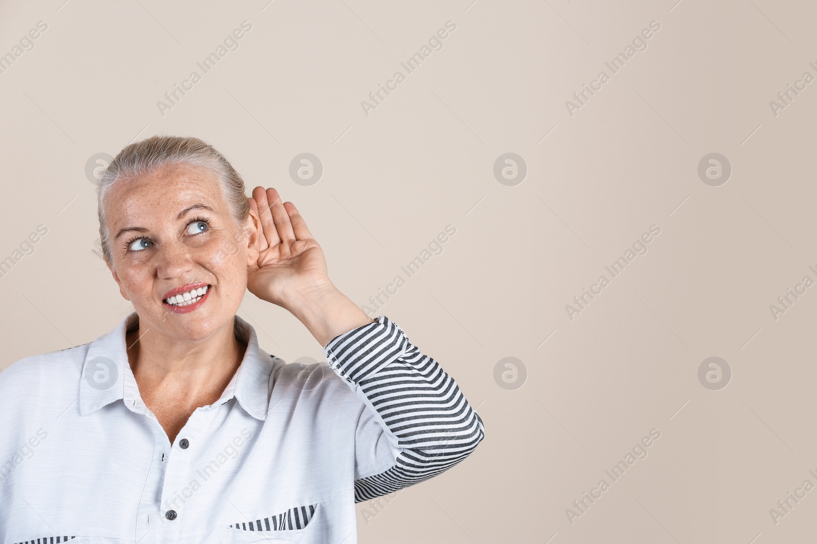 Photo of Mature woman with hearing problem on light background. Space for text