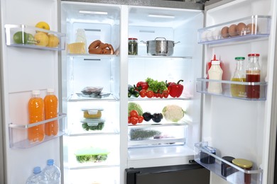 Modern open refrigerator full of different products