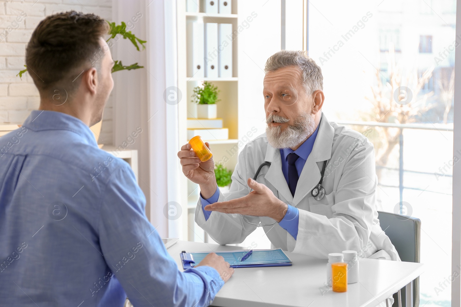 Photo of Mature doctor consulting patient in clinic