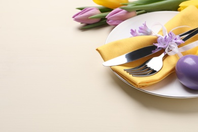Photo of Festive Easter table setting with egg on beige background. Space for text