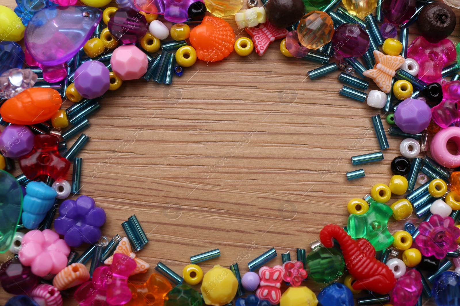 Photo of Frame of colorful beads on wooden background, flat lay. Space for text