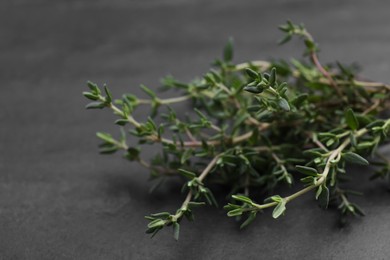 Photo of Aromatic fresh thyme on black table, closeup
