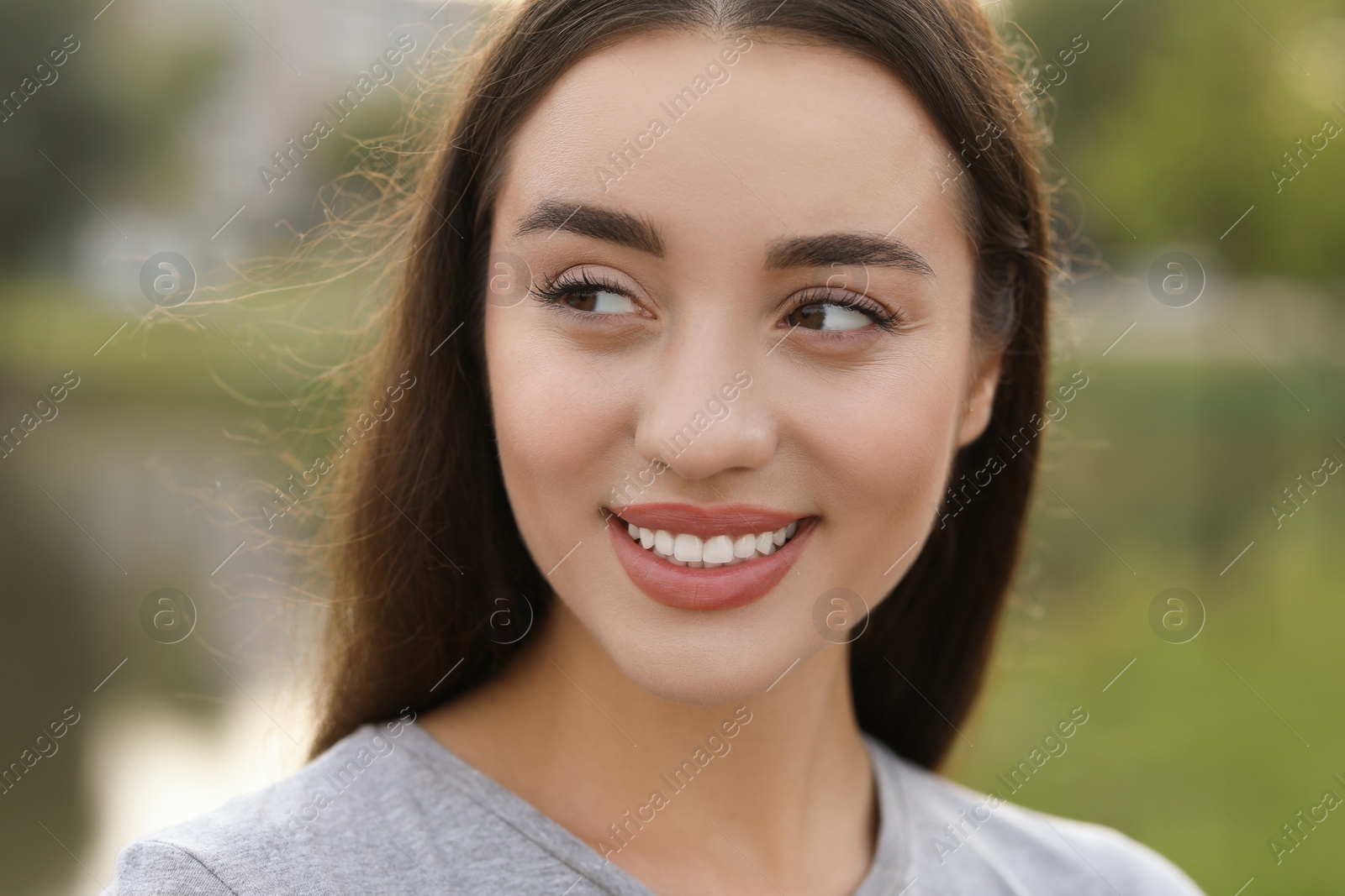 Photo of Portrait of beautiful woman on blurred background. Attractive lady smiling and posing for camera