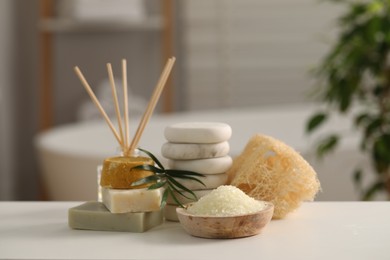 Photo of Composition with different spa products and palm leaves on white table in bathroom