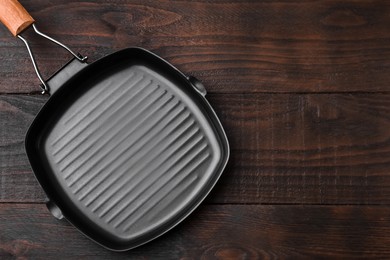 Photo of One grill frying pan on wooden table, top view with space for text. Cooking utensil