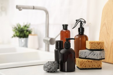 Different cleaning supplies on countertop in kitchen. Space for text