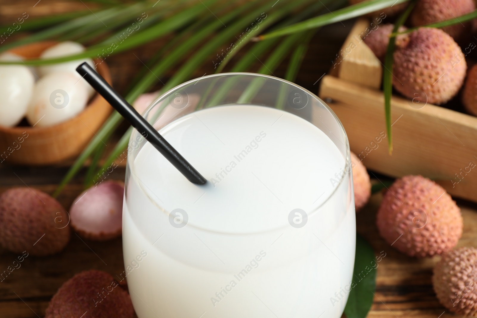 Photo of Freshly made lychee juice on wooden table, closeup